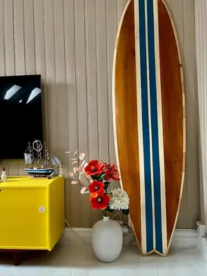 a room with a vase of flowers and a surfboard at Authentic top floor pearl in the city Center in Ålesund
