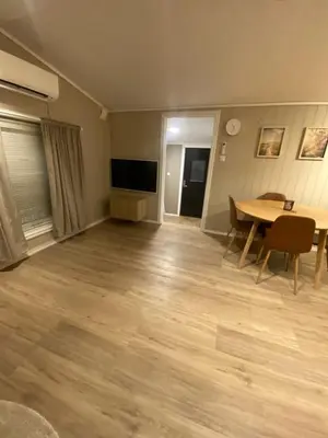 an empty living room with a table and a television at Furnished outhouse in Bergen