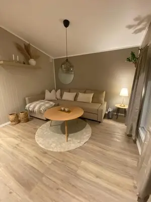 a living room with a couch and a table at Furnished outhouse in Bergen