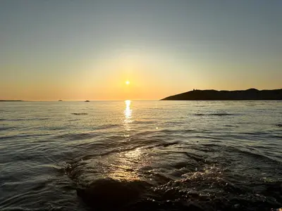 a sunset over a body of water with the sun setting at Unik og moderne microhytte med utsikt mot havet 40 A in Longva