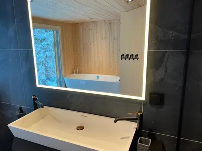 a bathroom with a large mirror and a tub at Retreat ved Spa hotell med Ski in & out, Norefjell in Surteberg