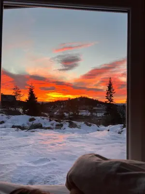 a view of a sunset through a window with snow at Retreat ved Spa hotell med Ski in & out, Norefjell in Surteberg