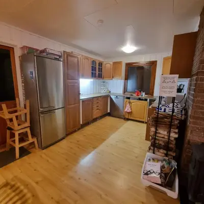 a kitchen with a stainless steel refrigerator and wooden cabinets at A house for rent in Osen, only 45 min from Trysil in Åmot
