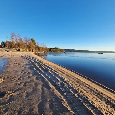 a beach with footprints in the sand next to the water at A house for rent in Osen, only 45 min from Trysil in Åmot