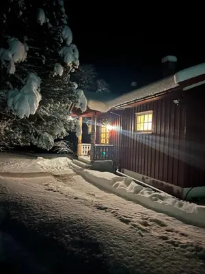 a cabin in the snow at night with a christmas tree at Bestemorhuset in Øye
