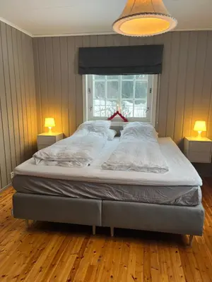 a large bed in a bedroom with two lamps at Bestemorhuset in Øye