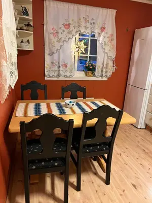 a kitchen with a table and chairs and a window at Bestemorhuset in Øye