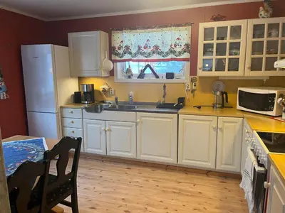 a kitchen with white cabinets and a white refrigerator at Bestemorhuset in Øye