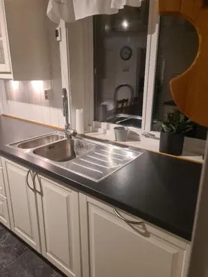 a kitchen counter with a sink and a mirror at Holiday home Hemnskjel in Hitra