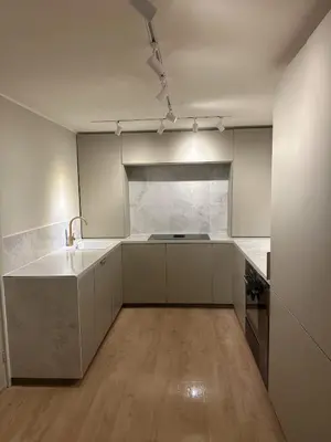 a kitchen with white cabinets and a sink in it at leilighet in Bergen