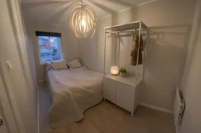 a small bedroom with a bed and a window at leilighet in Bergen