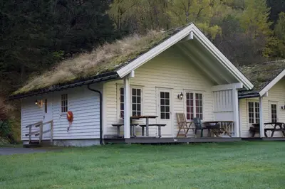 a small white house with a grass roof at Hjelledalen Hyttesenter in Hjelle