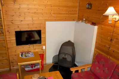 a living room with a fireplace and a flat screen tv at Hjelledalen Hyttesenter in Hjelle