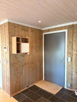 a room with a door and a wall of wood at Apartment in the Center of Geilo in Geilo