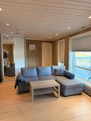 a living room with a blue couch and a table at Apartment in the Center of Geilo in Geilo