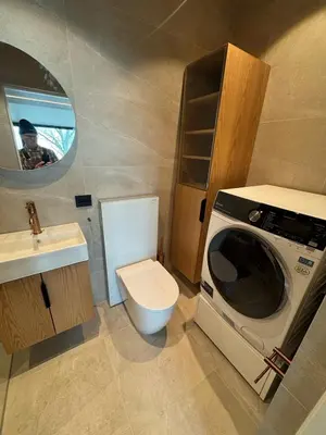 a small bathroom with a toilet and a washing machine at NerSalberg Farm