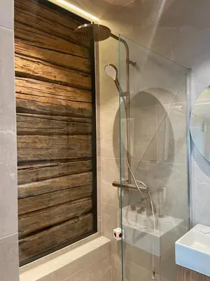 a bathroom with a glass shower with a sink at NerSalberg Farm