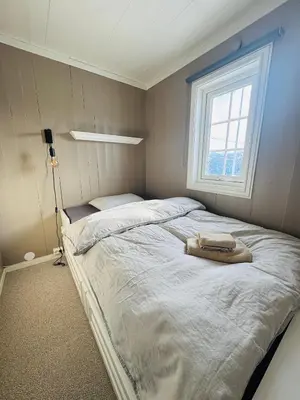 a bedroom with a large bed with a window at Cozy cabin in the middle of peaceful surroundings in Geilo