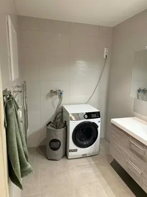 a washing machine sitting in the corner of a bathroom at Large apartment, in the middle of Gol city center! in Gol