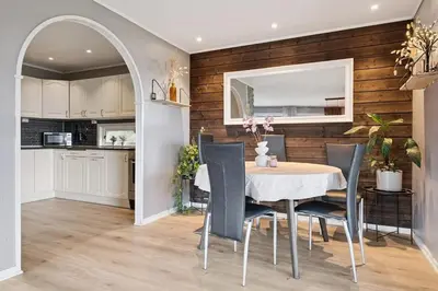 a kitchen and dining room with a table and chairs at Enebolig med 5 soverom in Lii