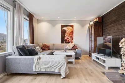 a living room with a couch and a tv at Enebolig med 5 soverom in Lii