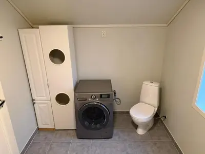 a small bathroom with a washing machine and a toilet at Charming sea view in Bergen