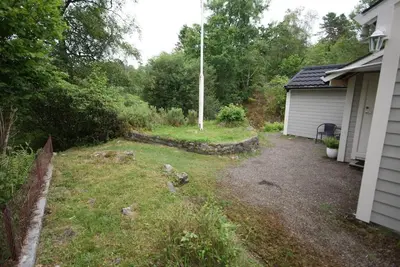 a yard next to a house with a fence at Charming sea view in Bergen