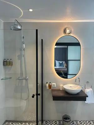 a bathroom with a sink and a shower with a mirror at Granavolden Hotel & Gjæstgiveri in Gran