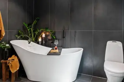 a white bath tub in a bathroom with a toilet at Solglimt, mountain cabin in Golsfjellet with jacuzzi in Gol