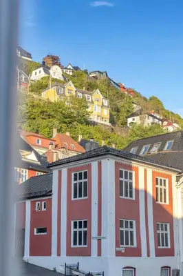 a red and white building with houses on a hill at Bryggen Gateway Homes in Bergen
