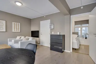 a living room with a bed and a television at Bryggen Gateway Homes in Bergen