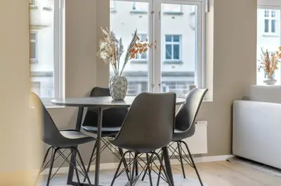 a dining room with a table and chairs and a window at Bryggen Gateway Homes in Bergen