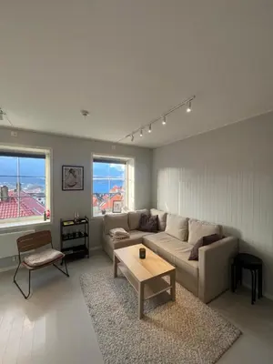a living room with a couch and a coffee table at Nice and central apartment in Sandviken with sea view in Bergen