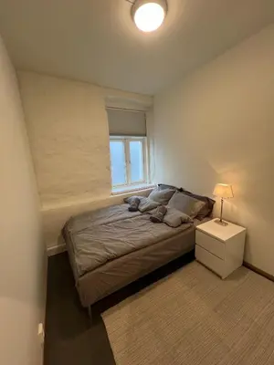 a bedroom with a large bed with a window at Apartment in the heart of Bergen in Bergen