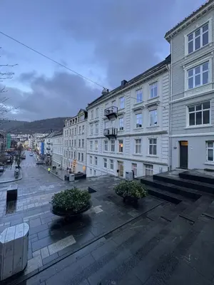 an empty city street with buildings and potted plants at Apartment in the heart of Bergen in Bergen
