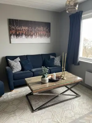 a living room with a blue couch and a table at 5 Bedroom House at Hakallestranda in Sandvik