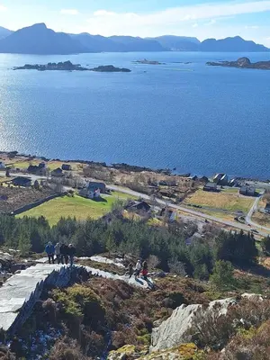 a group of people standing on top of a hill near the water at 5 Bedroom House at Hakallestranda in Sandvik