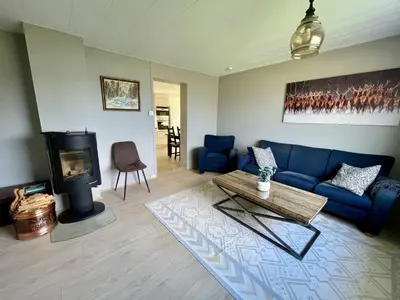 a living room with a blue couch and a fireplace at 5 Bedroom House at Hakallestranda in Sandvik