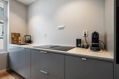 a kitchen with white cabinets and a counter top at Renovated Apartment in Central Area in Bergen