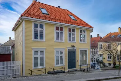 a yellow house with an orange roof at Renovated Apartment in Central Area in Bergen