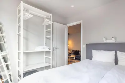 a bedroom with a white bed and white shelves at Nice apartment with three bedrooms in the middle of Bergen! in Bergen
