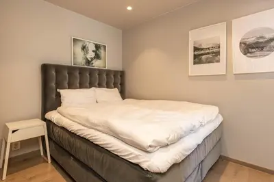 a bedroom with a large bed with white sheets at Nice apartment with three bedrooms in the middle of Bergen! in Bergen