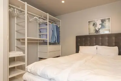 a bedroom with a white bed and a closet at Nice apartment with three bedrooms in the middle of Bergen! in Bergen