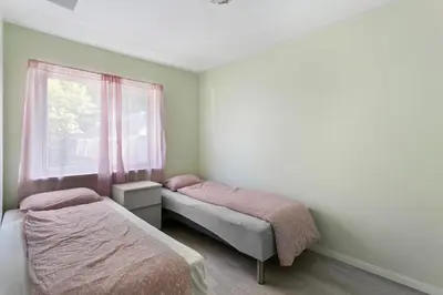 two beds in a room with a window at Centrum apartment 1 in Ålesund
