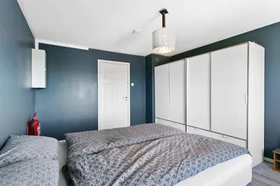 a bedroom with a bed and a blue wall at Centrum apartment 1 in Ålesund