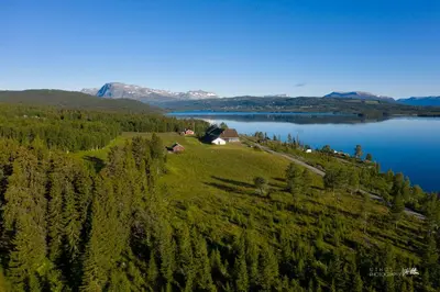 an island with a house on a hill next to a lake at Modern apartment in Golsfjellet in Gol