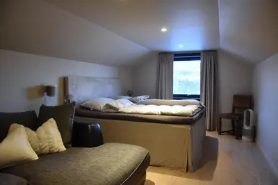 a bedroom with two beds and a couch and a window at luxury home with jacuzzi in Geilo