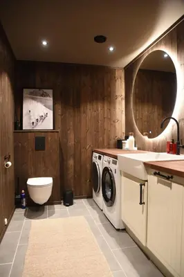 a bathroom with a washing machine and a sink at luxury home with jacuzzi in Geilo