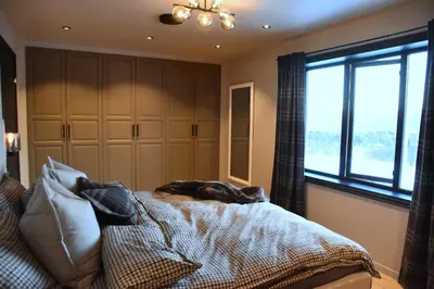 a bedroom with a bed with a dog laying on it at luxury home with jacuzzi in Geilo