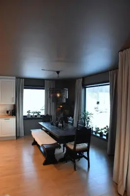 a dining room with a table and chairs and windows at luxury home with jacuzzi in Geilo